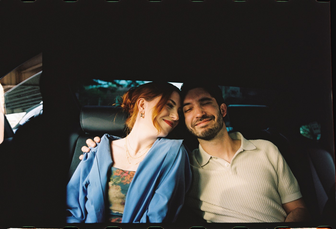Emma and Gaston sitting together in a car
